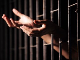 hands of prisoner in jail.